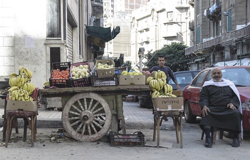 Escena de calle junto a un puesto de fruta